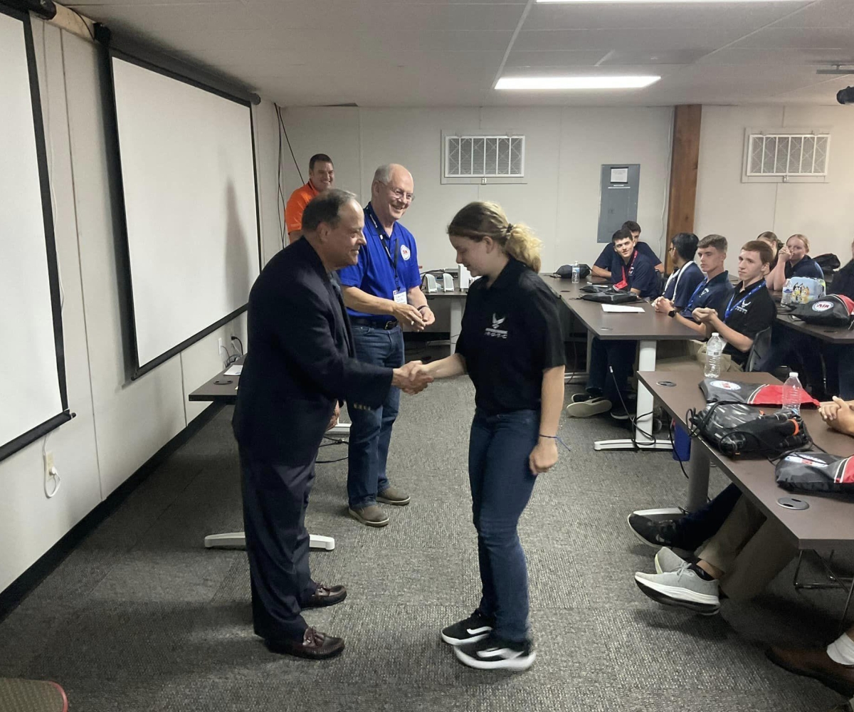 JROTC Cadets receiving Air Camp coins from Rafi Rodriguez (foreground) and Air Camp Board Member Lt Gen (Ret) Dick Reynolds